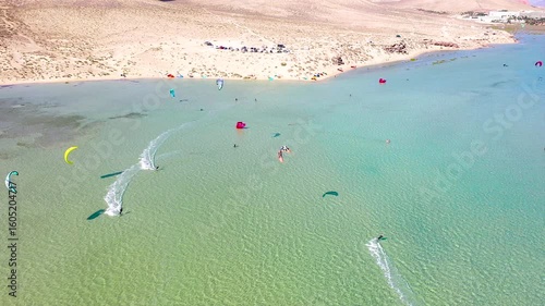 Aerial view of a crowd of kitesurfers enjoying the waves on the beach of Sotavento, Fuerteventura Island, Spain.
