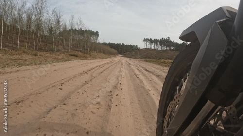 Motorcycle riding on loose sandy road. Motorcycle front suspension on bumpy road.