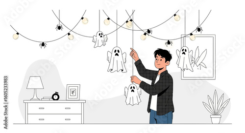 Young Man Prepares Halloween Decorations Hanging Ghosts and Spiders At Home