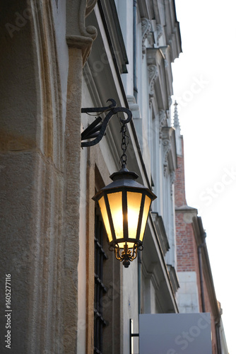 Lantern glows above heritage. Stone tells old stories. Window reflects memory. Every element here resists time and insists on presence.

