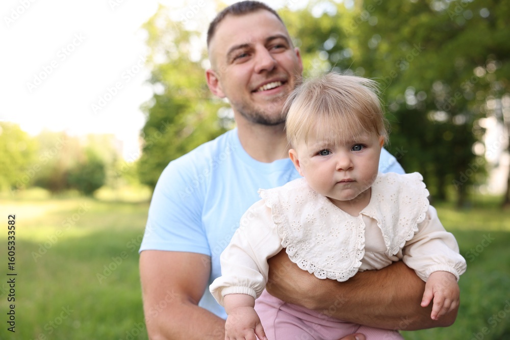 Fototapeta premium Smiling dad and his newborn baby outdoors. Happy Father's Day