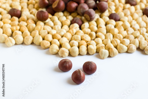 Shelled and unshelled, double roasted, luxury Turkish hazelnuts, designed together on a white surface