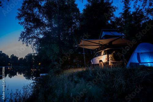 Romantic Camping at the lake with 4x4 Offroad vehicle with roof tent at night