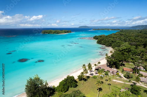 Vibrant coastal landscape of Port Olry village in Espiritu Santo, Vanuatu with clear blue waters and lush greenery