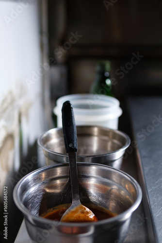 Preparing pizza tomato sauce in restaurant kitchen