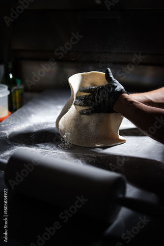 Chef preparing pizza dough in restaurant kitchen