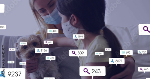 Holding dog mother-daughter wearing face masks, sitting on sofa at home, floating digital overlays