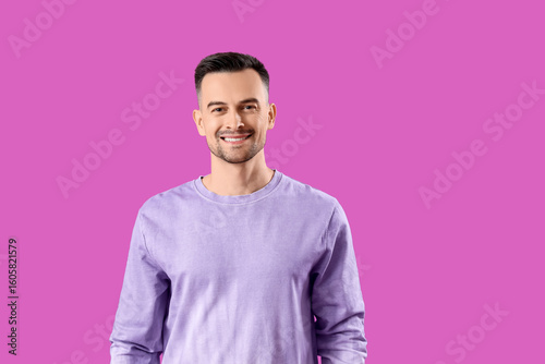 Happy young man on purple b...
