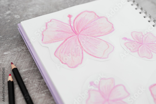 sketchpad with pink flower drawings and pencils on a creative desk setup