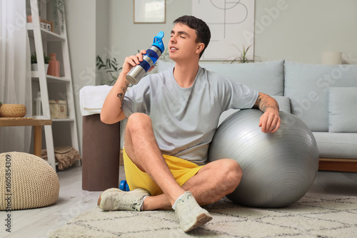 Sporty young man with bottl...