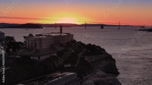 Alcatraz Island, USA, stands silhouetted against a vibrant sunset. The former prison and landmark is a popular tourist destination, offering tours and history.