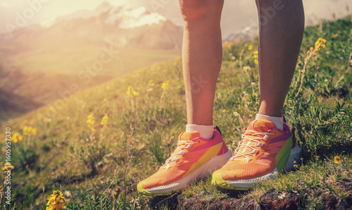 Trail runner running on the high altitude grassland mountain top trail