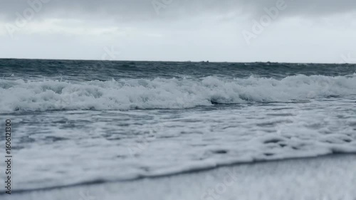 水平線と白い波が割れる初夏の波打ち際