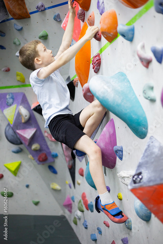 child at indoor climbing wall. Kid having fun at bouldering wall. Child learning at climbing class. Sports healthy lifestyle. climbing summer camp