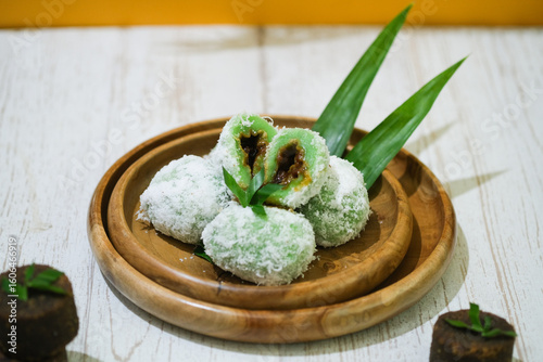 Onde - Onde.Traditional cakes from Manado, North Sulawesi, Indonesia. Made with sticky rice flour, a coating of delectable grated coconut, and a filling of brown sugar that melts in your mouth.flatlay