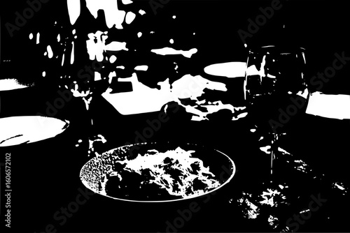 A monochrome image displaying a table set with a plate of food and glasses in a dimly lit environment