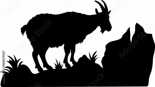 Silhouette of a goat standing on a rocky outcrop with grass