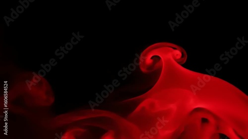 Abstract red smoke slowly swirling and billowing against a dark black background