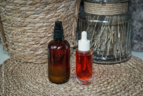 Obraz na plátně Amber glass bottle and transparent dropper bottle with homemade natural beta-carotene body oil on beige background