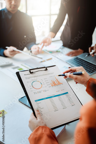 Young colleagues discuss business and analytical price charts using calculators and laptops to calculate financial, tax, accounting, statistics and analytical research ideas.