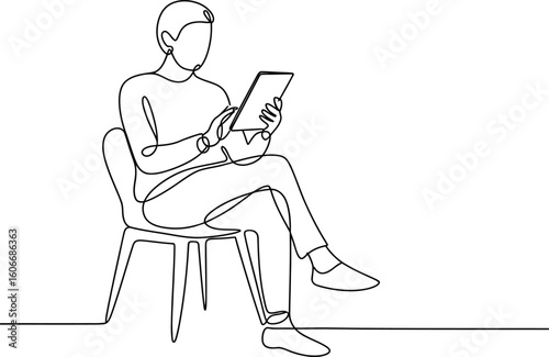 Man sitting on chair holding and looking at a tablet computer
