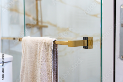 Cuadro en lienzo Zoom sur les différents éléments d’une salle de bain moderne avec marbre blanc à rainures dorées, colonne de douche, robinetterie et accessoires en finition bronze doré