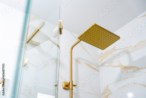 Obraz na plátně Zoom sur les différents éléments d’une salle de bain moderne avec marbre blanc à rainures dorées, colonne de douche, robinetterie et accessoires en finition bronze doré