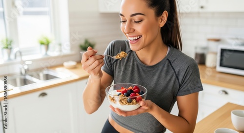 Wallpaper Mural Woman Enjoying a Healthy Breakfast in Her Kitchen. A woman stands in her kitchen, holding a bowl of yogurt topped with granola and fresh berries.  Torontodigital.ca