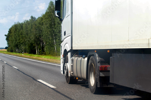 Wallpaper Mural A truck with a semi-trailer drives along a highway against the backdrop of a forest in summer. Concept of won cargo tenders, carrier rating. Copy space for text Torontodigital.ca