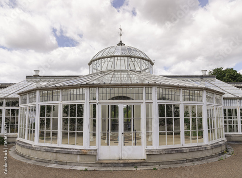 Fotografi Victorian architecture of the Conservatory at Chiswick House and gardens, featuring a striking domed roof, curved glass panels, and intricate white ironwork, It was originally designed as a hothouse