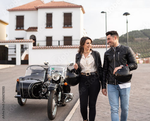 Attractive couple on sidecar bike walking in the street os spanish city