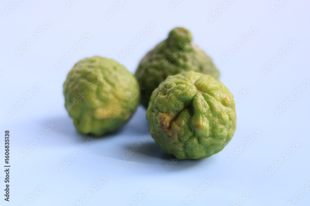 Fototapeta premium Kafir lime is unique citrus fruit known for its bumpy texture and vibrant green color, often used culinary dishes and traditional remedies. Its aromatic leaves and zest add distinct flavor to