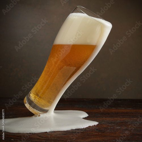 Beer. Jet of beer is poured into a beer glass, causing a lot of bubbles and foam