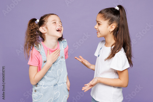 Fotomural Little smiling cheerful cool two friends kids children girls 9-10 years old wear casual clothes together talking with each other laugh tell joke isolated on plain purple background