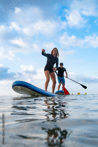 Couple engaged in paddleboard contest on the water