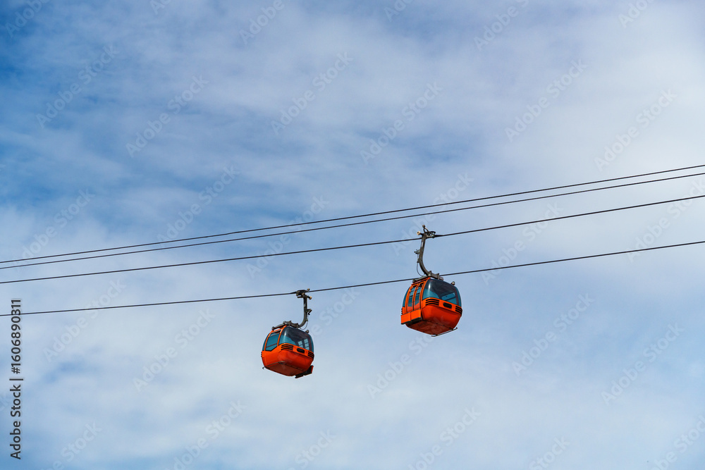 cabins of funicular, cable car, against background of blue sky with white clouds cabins of funicular, cable car, against background of blue sky with white clouds