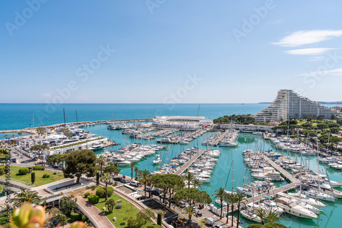 Aerial view of Marina Baie des Anges in Villeneuve-Loubet – luxury yachts, turquoise water, iconic pyramid buildings and Mediterranean Sea on the French Riviera