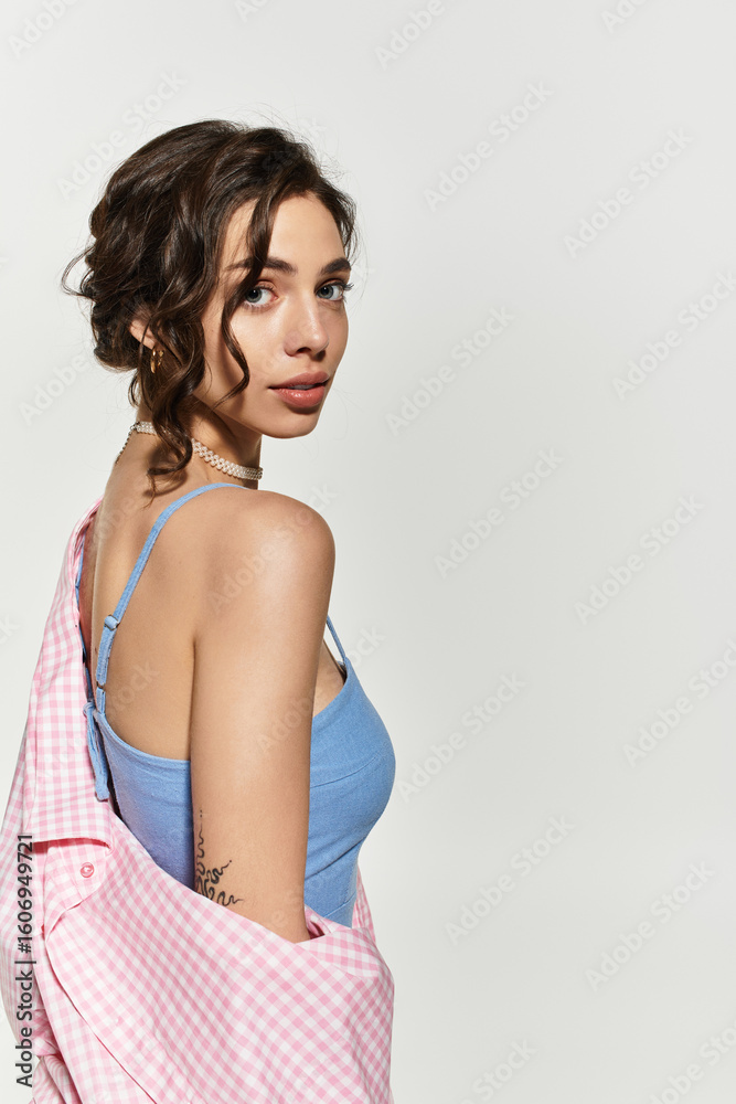 Fototapeta premium Stunning young woman in blue summer dress posing gracefully in studio atmosphere