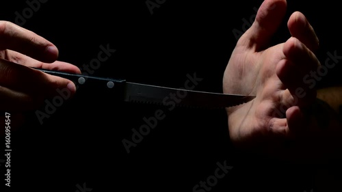 Robber with a knife in a black room preparing to attack.
Serial killer with a steel knife in his hands wants to rob someone.
Robber or criminal with a sharp knife in his hands at night
