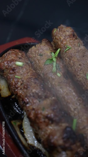 Sizzling Hot Seekh Kebabs on a Platter with Onions