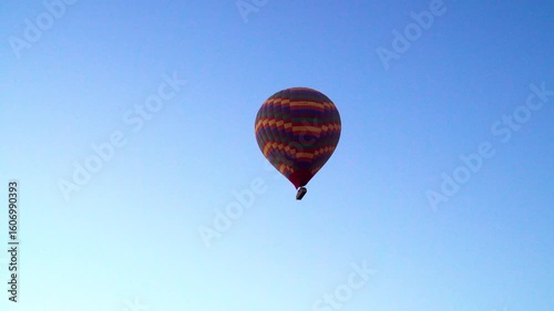 Hot air balloon rising into blue sky