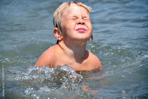Little Boy Learning to Swim in the Sea on a Sunny Summer Day