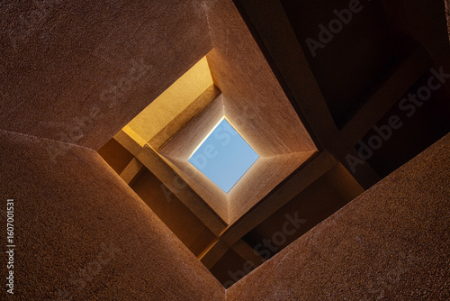 Modern Architecture Looking Up Through Geometric Building Structure to Blue Sky