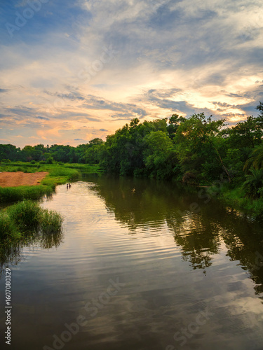 sunset over the river in the rural Bengal, India