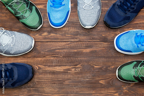 Obraz na płótnie Top view shop display of unbranded modern new stylish sneakers running shoes for men on wooden background texture with copy space