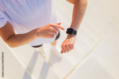 Wall Mural Fitness enthusiast checking smartwatch during a morning jog session