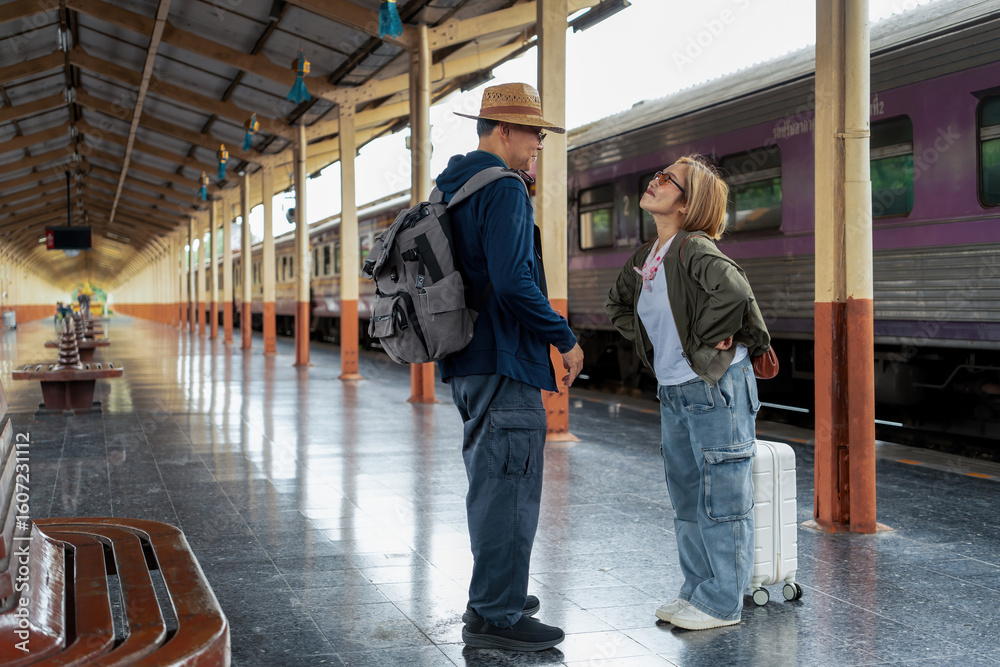 Fototapeta premium Happy Asian senior boarding a train at the station