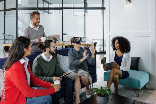 Fototapeta Group of young latin business people using virtual reality glasses during meeting testing VR headset at office in Mexico Latin America