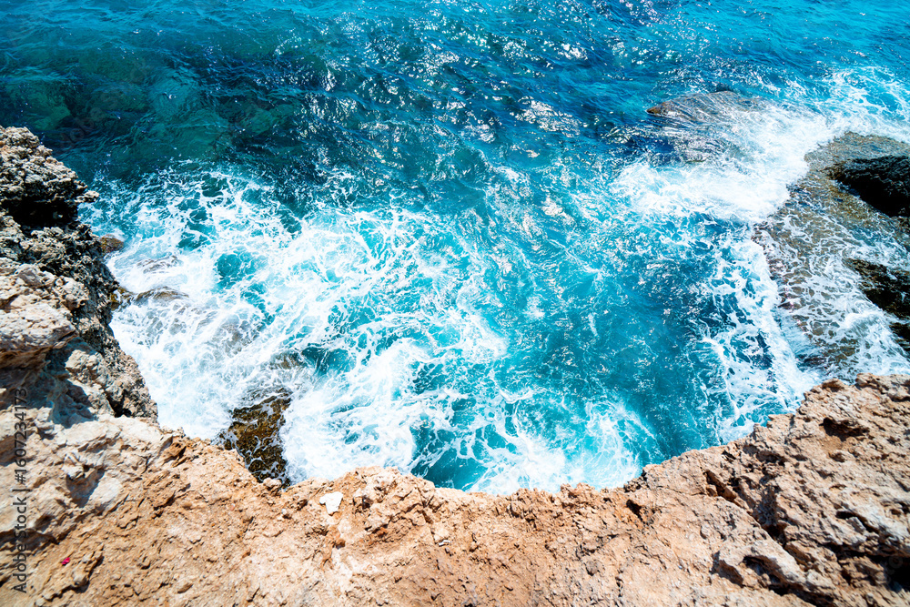Obraz premium Aerial view on turquoise sea waves crashing against the rocks, Ayia Napa, Cyprus. 