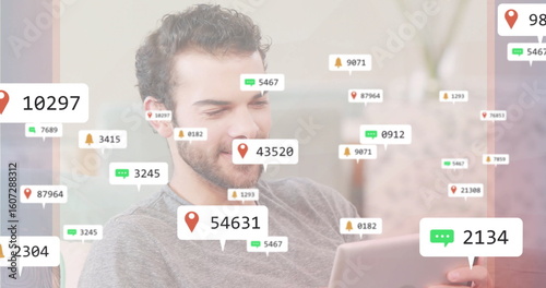 Checking tablet, man wearing grey top interacting with floating notification icons in living room